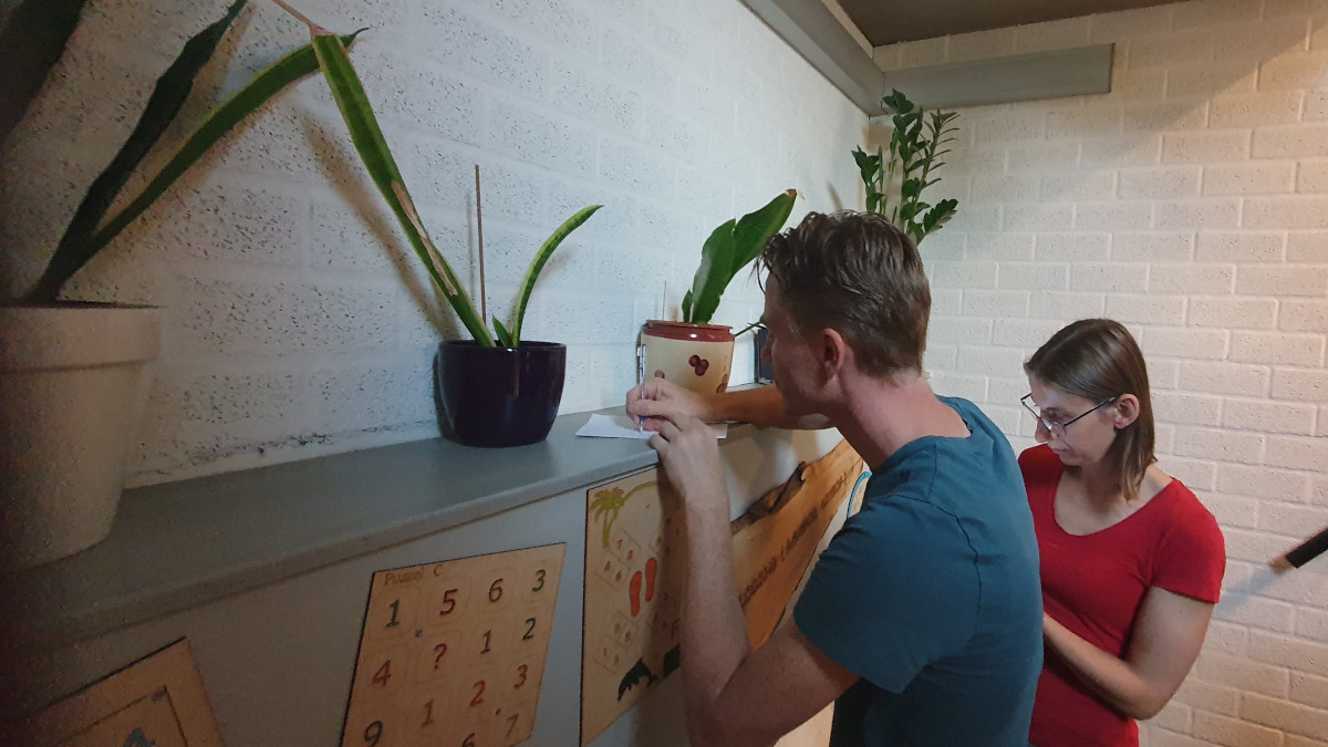 Twee personen zijn bezig met het oplossen van de cijferpuzzels tijdens het MasterMinds spel.
