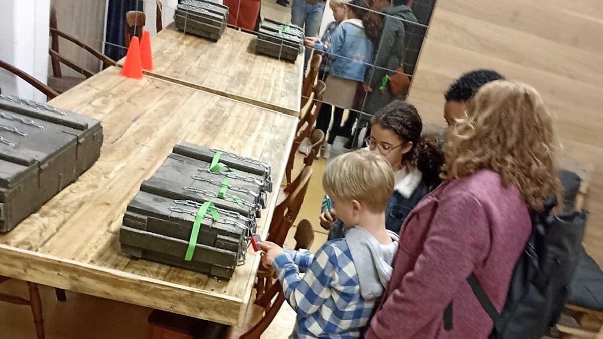 Een gezin probeert het cijferslot van de kist te openen.