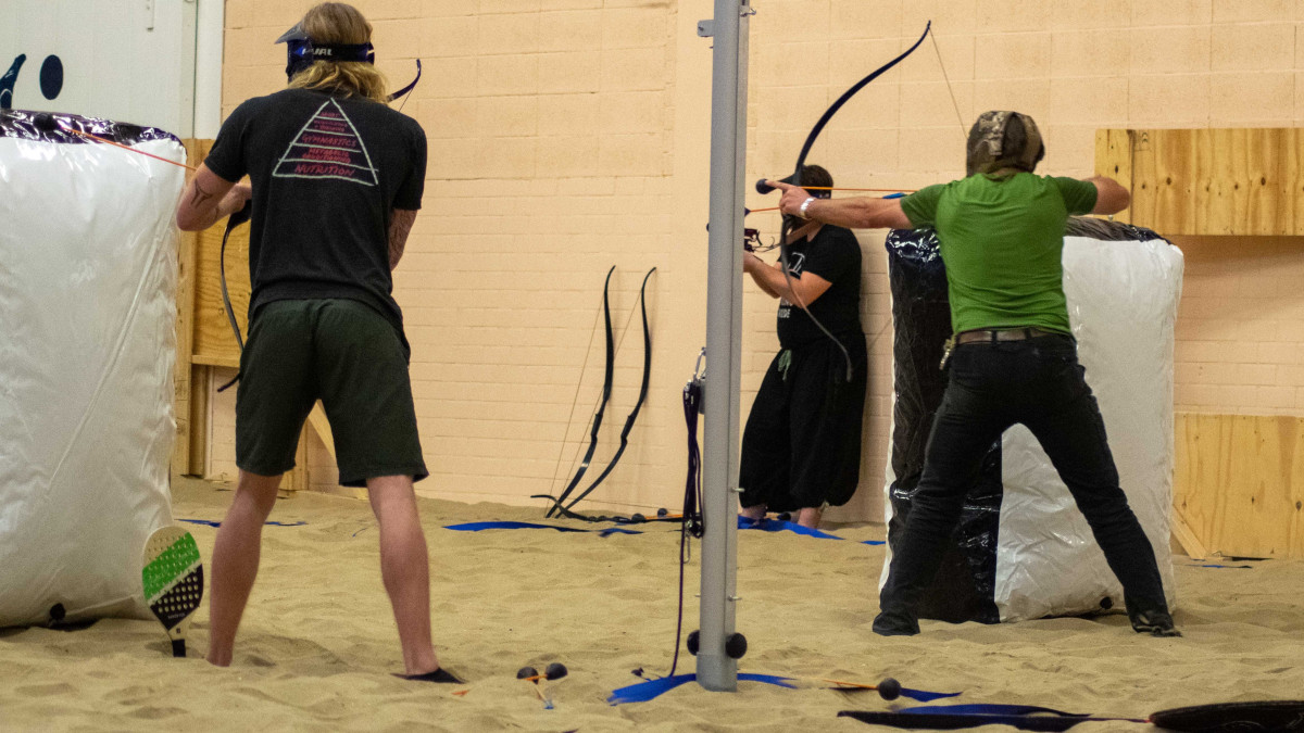 Twee personen richten hun pijlen op de tegenpartij tijdens Archery Tag.