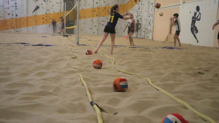 De dodgeballen liggen klaar op het zand.