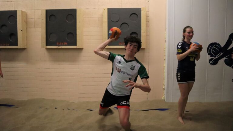 Een jongen gooit een bovenhandse worp met dodgeball.