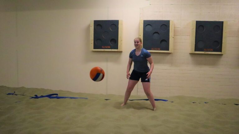 Er komt een dodgeball af op een dame die klaar staat om deze te ontwijken.