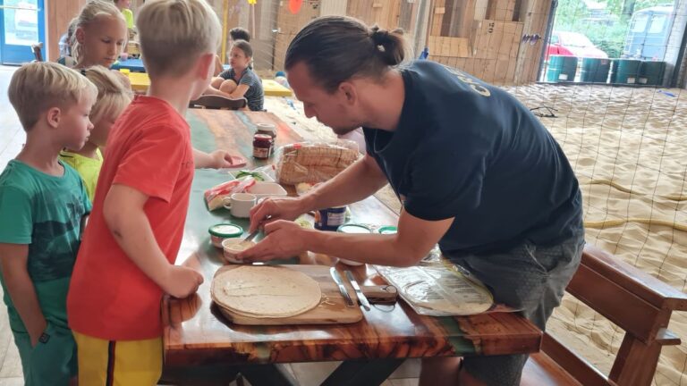 De instructeur helpt met het besmeren van de wrap.
