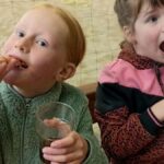 Twee meisjes eten pizza en drinken frisdrank tijdens het kinderfeestje bij Indoor Beach Alkmaar.