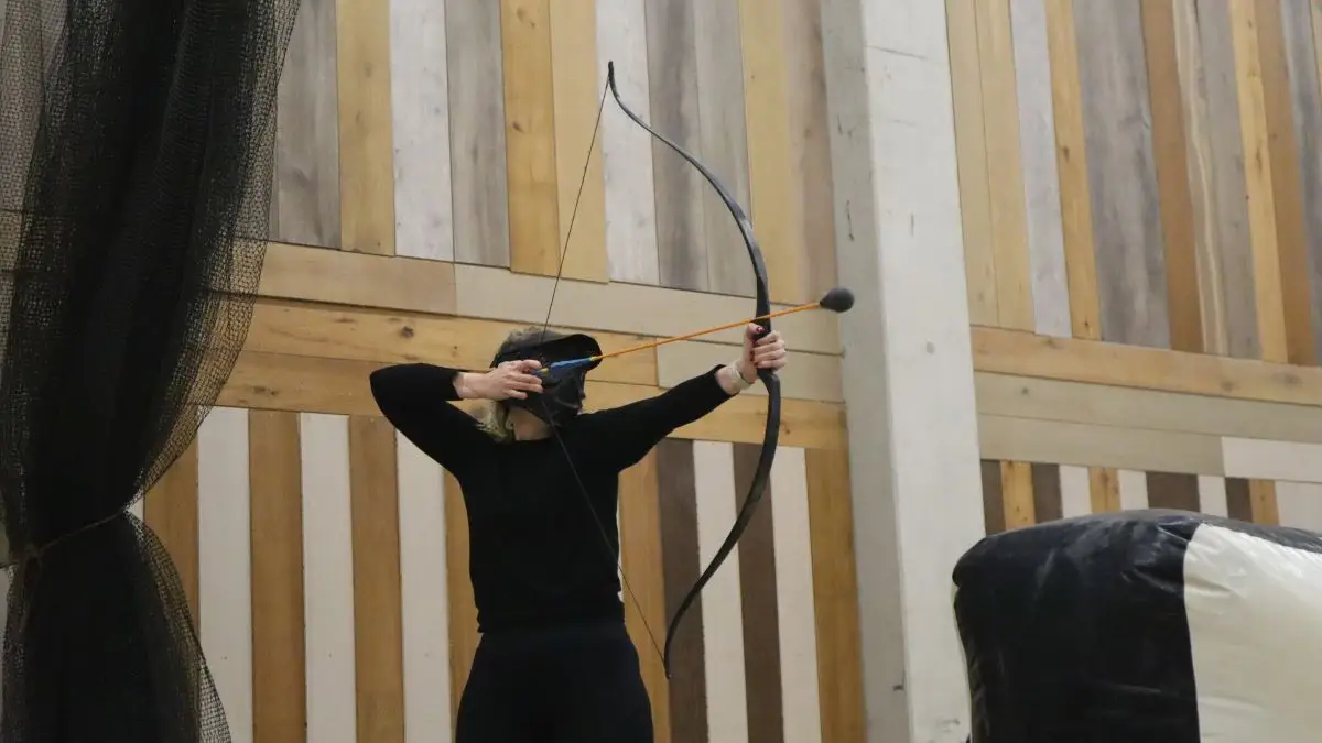 Iemand heeft de boog gespannen tijdens Archery Tag, klaar om te schieten.
