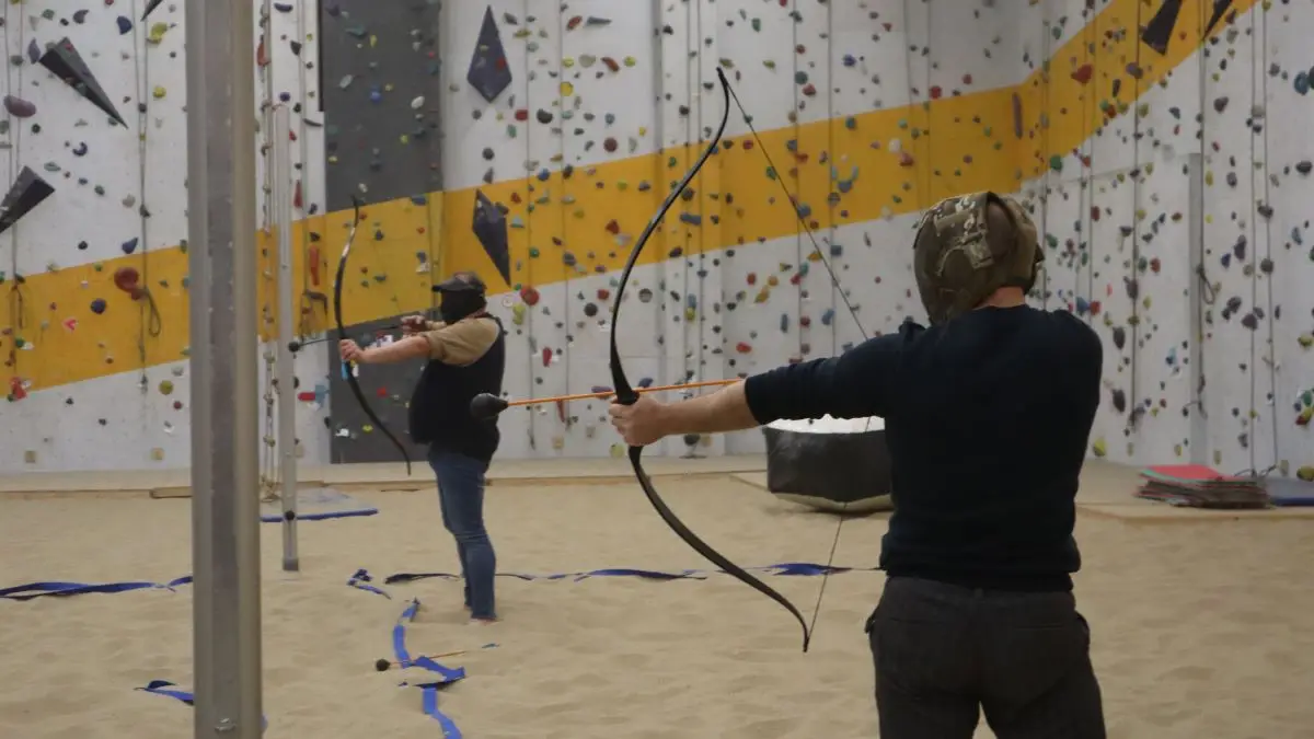 Een team van 2 mannen richten hun pijlen tijdens Archery Tag.