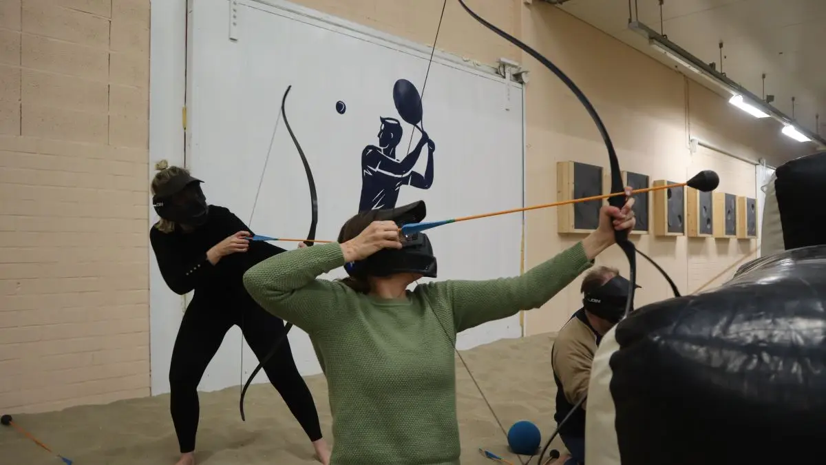 Een team van 3 personen verschuilen zich achter de obstakels tijdens Archery Tag.
