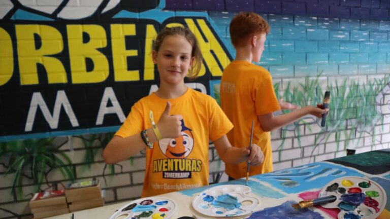 Aventuras Zomerkamp bij Indoor Beach Alkmaar. Een jongen lacht en steekt zijn duim omhoog.