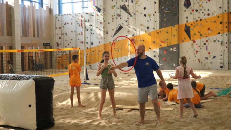 Aventuras Zomerkamp bij Indoor Beach Alkmaar. Mike doet een trucje met een hoepel.