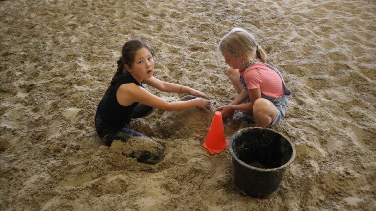 Aventuras Zomerkamp bij Indoor Beach Alkmaar. Twee meisjes spelen in het zand.